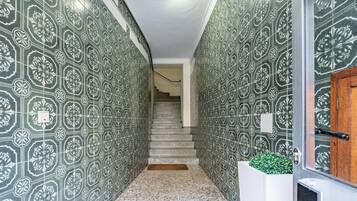Un pasillo con paredes decoradas y una escalera que lleva a otra habitación.