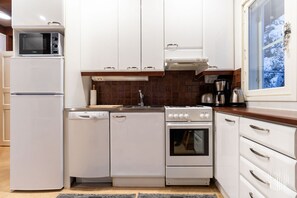 Une cuisine compacte équipée d’un réfrigérateur, d’un lave-vaisselle, d’un four à micro-ondes, d’une cuisinière et d’un four.