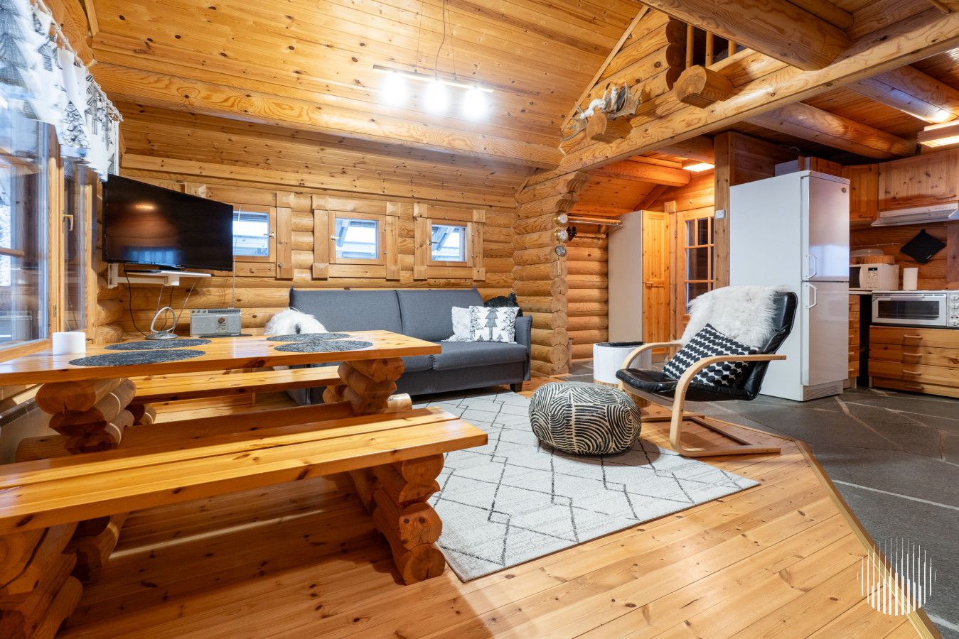 L’intérieur d’une cabane en rondins comprend un coin repas, un canapé et une cuisine.