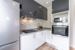 A modern kitchen with a built-in oven, microwave, and stainless steel appliances. - Nomad s Family - 2bdr The Docks in Porto (Porto)