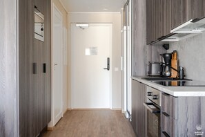 Eine moderne Küche mit Holzausstattung, einem eingebauten Backofen und einer Arbeitsplatte mit Kochutensilien.