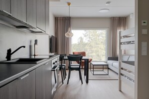 Une cuisine moderne avec un coin repas, un canapé et un lit superposé.