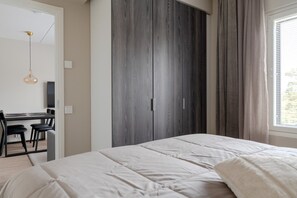 Ein Schlafzimmer mit einem Bett, einem Schreibtisch mit Stühlen und einem Kleiderschrank.