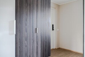 Une pièce avec une armoire en bois, une porte blanche et un mur de couleur claire.