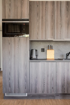 A kitchen with a built-in microwave, a coffee maker, and a knife block on the countertop. - Äkäsentie 1 A 313 by Holiday in Lapland (Äkäslompolo)
