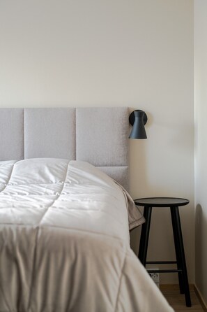 A bed with a headboard, a small round table, and a floor lamp. - Äkäsentie 1 A 301 by Holiday in Lapland (Äkäslompolo)