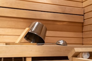 A wooden structure with a metal object and a smaller metal item on a shelf. - Sivulantie 4 209 by Holiday in Lapland (Äkäslompolo)