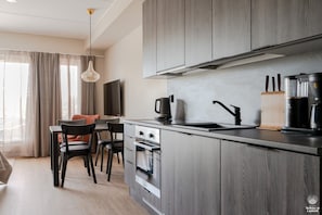 Une cuisine moderne dotée d’un îlot central, d’un four encastré et d’appareils électroménagers en acier inoxydable.