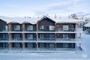 A multi-story hotel with balconies and large windows, surrounded by snow. - Äkäsentie 1 A 210 by Holiday in Lapland (Äkäslompolo)