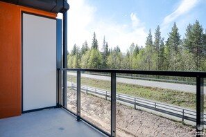 A balcony with a view of a road and forest. - Äkäsentie 1 A 211 by Holiday in Lapland (Äkäslompolo)