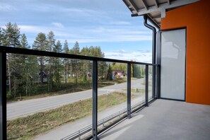 A balcony with a metal railing overlooking a road and trees. - Äkäsentie 1 A 312 by Holiday in Lapland (Äkäslompolo)