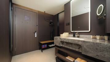 A modern bathroom with a large mirror, a sink, and a towel rack.