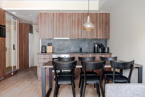 Eine moderne Küche mit Holzausstattung, einer Mittelinsel und schwarzen Stühlen.
