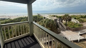 Un balcón con vista a una playa y un paseo marítimo.