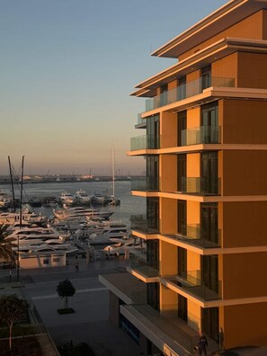 A modern multi-story building with balconies overlooking a marina with boats. - 2BR at Seagate Marina  Yacht Views, Sleeps 6, Pool and Gym (Dubai)