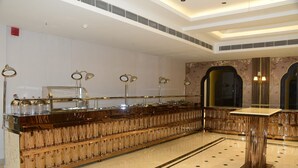 Zona de bar amb una barra llarga, nombrosos suports per a tasses i il·luminació penjant.