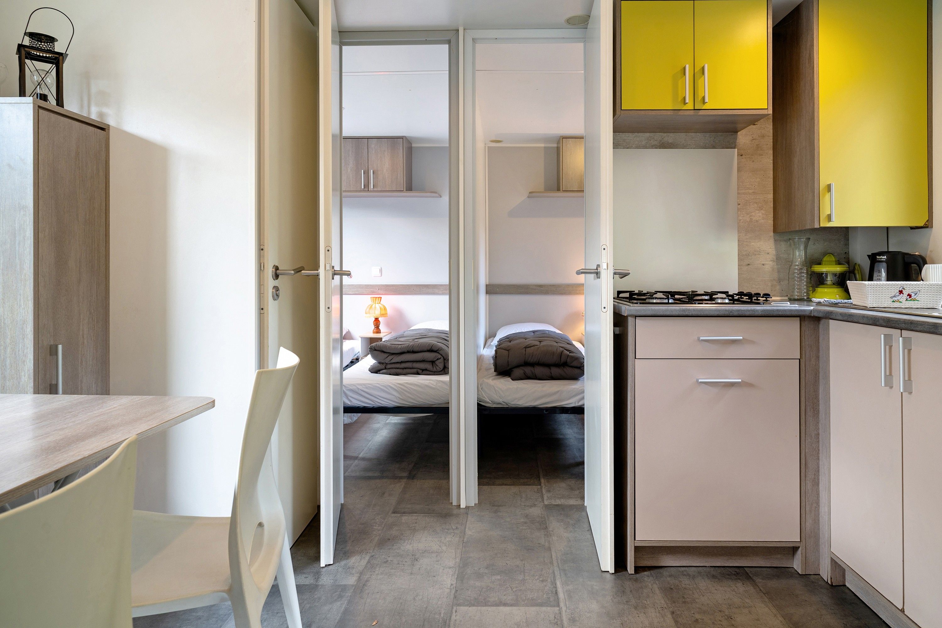Een kleine slaapkamer met een bed, nachtkastje en een klein raam.