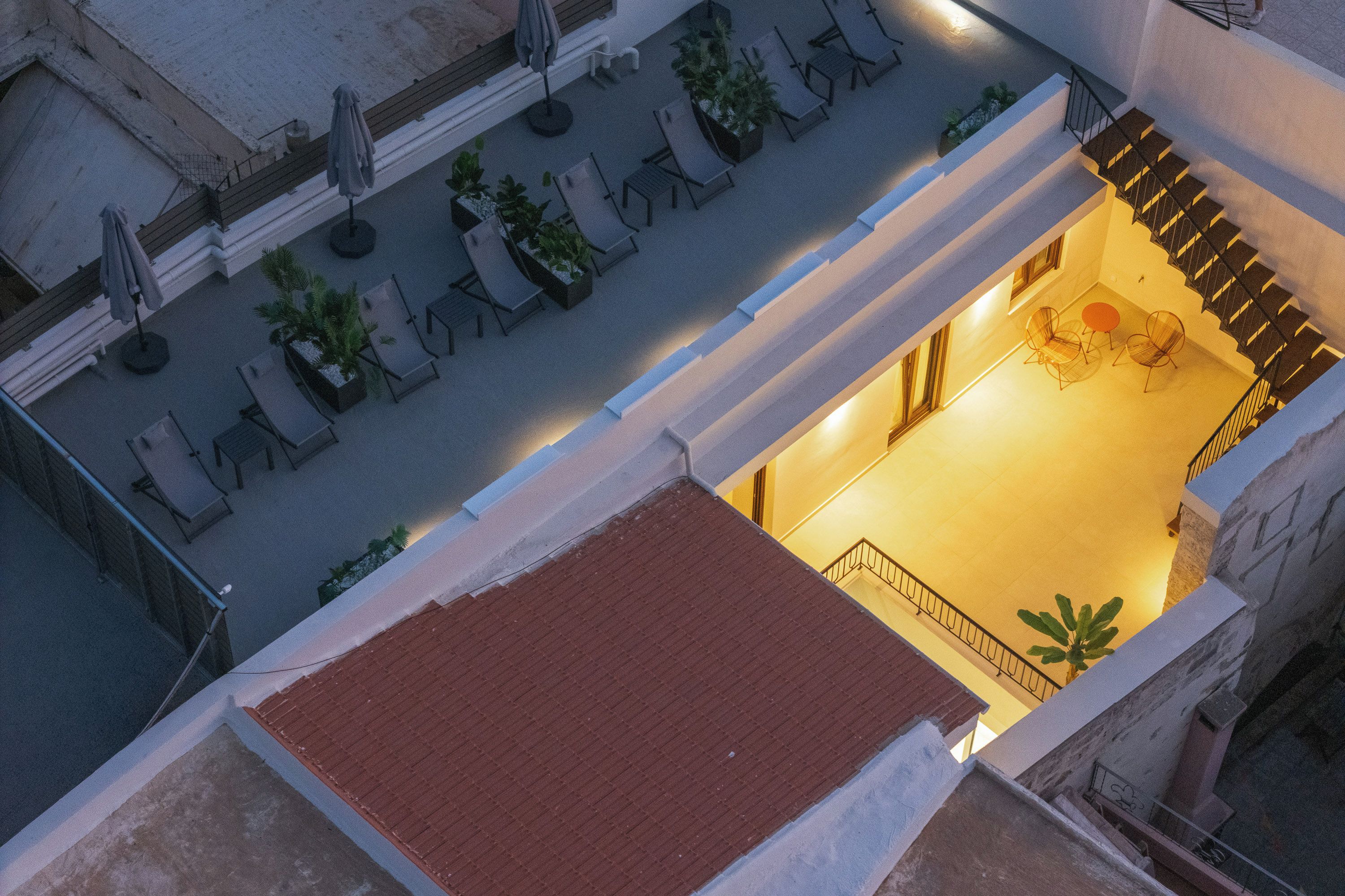 An aerial view of a courtyard with outdoor seating and a staircase leading to an upper level.