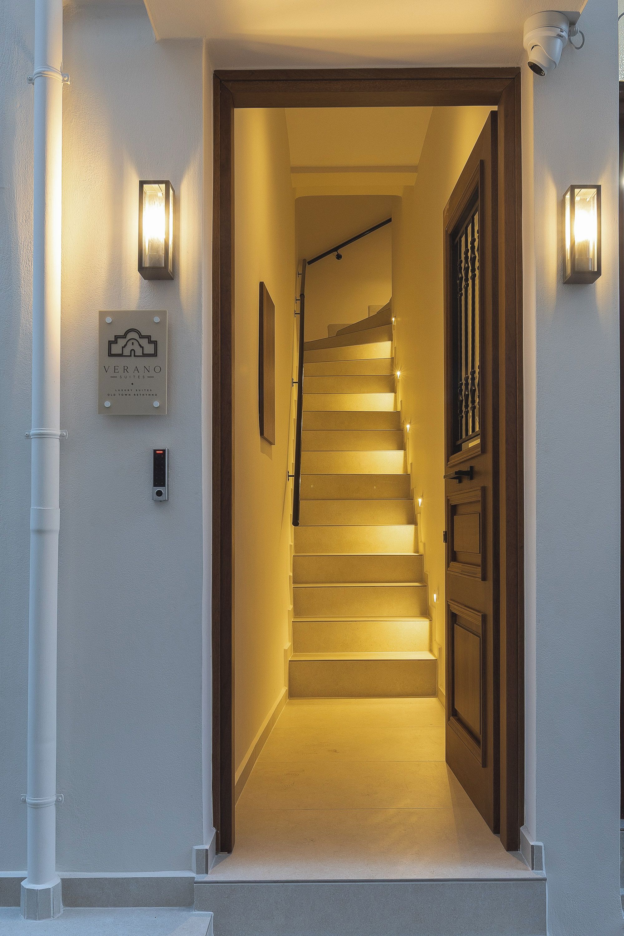 Eine Treppe führt zu einer Tür, über der ein Schild hängt.