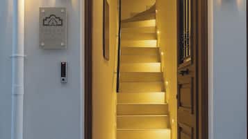 Eine Treppe führt zu einer Tür, über der ein Schild hängt.
