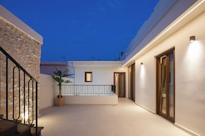 Ein modernes Gebäude mit einem Balkon, einem Blumentopf und einer Treppe.