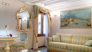 Ein Zimmer mit einer gestreiften Couch, einem runden Tisch, einem Stuhl, einem Spiegel und einem Stadtbild.