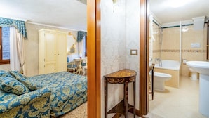 Ein Schlafzimmer mit einem Bett, einem Schreibtisch und einem Badezimmer mit einer Badewanne und einem Waschbecken.