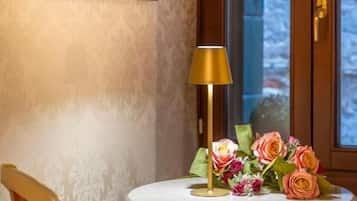 Una habitació amb una taula rodona, una làmpada i un arranjament floral.