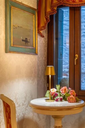 A room with a round table, a lamp, and a floral arrangement. - Casa Guggenheim (Venice)