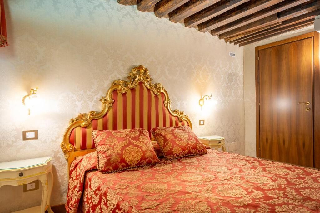 Une chambre à coucher avec un grand lit, une tête de lit décorée, deux tables de chevet et une armoire en bois.