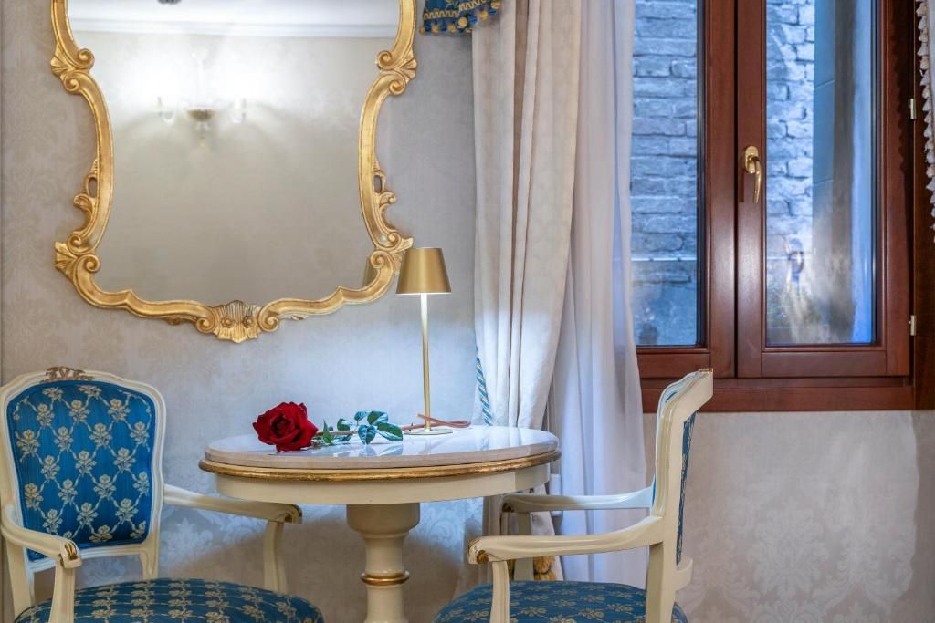 Une pièce avec une table ronde, deux chaises, un miroir, une lampe et une porte avec une fenêtre.