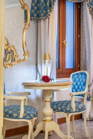A room with a round table, two chairs, a mirror, and a window with curtains. - Casa Guggenheim (Venezia)