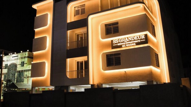 A multi-story building with illuminated signage indicating it is a service apartment complex. - SS Grandur  (Tiruchirappalli)