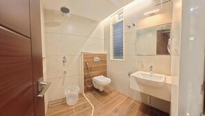 A modern bathroom with a toilet, sink, and shower. - SS Grandur  (Tiruchirappalli)