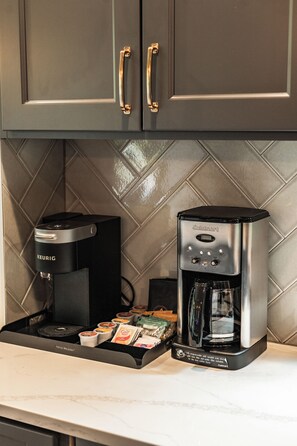 A coffee maker with a digital interface and a coffee pod holder on a kitchen counter. - Welcome to Seventeen Pines, a stunning Suncadia retreat overlooking Prospector Golf Course’s 17th hole. Enjoy soaring ceilings, a dramatic stone fireplace, private hot tub and beautiful views, all tucked among towering evergreens. (Cle Elum)