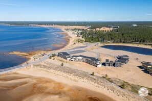 A coastal property with a beach, a road, and a building complex.