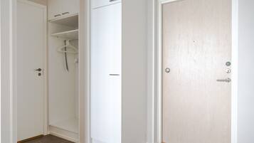 Una habitación con armario, una puerta y suelo cubierto de alfombra.