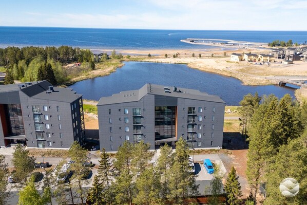 A modern apartment complex with a view of a lake and the sea.