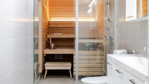 A modern bathroom with a glass shower enclosure, wooden shelves, and a white sink. - Marinan Portin Majakka B13 by Holiday in Kalajoki (Kalajoki)