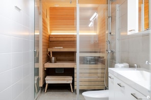 Een moderne badkamer met een douchecabine van glas, houten planken en een wit wastafelmeubel.