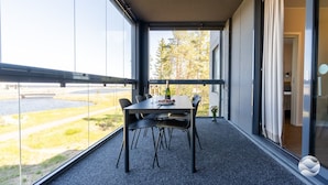 A balcony with a table and chairs, a bottle, and a glass of wine. - Marinan Portin Majakka B13 by Holiday in Kalajoki (Kalajoki)