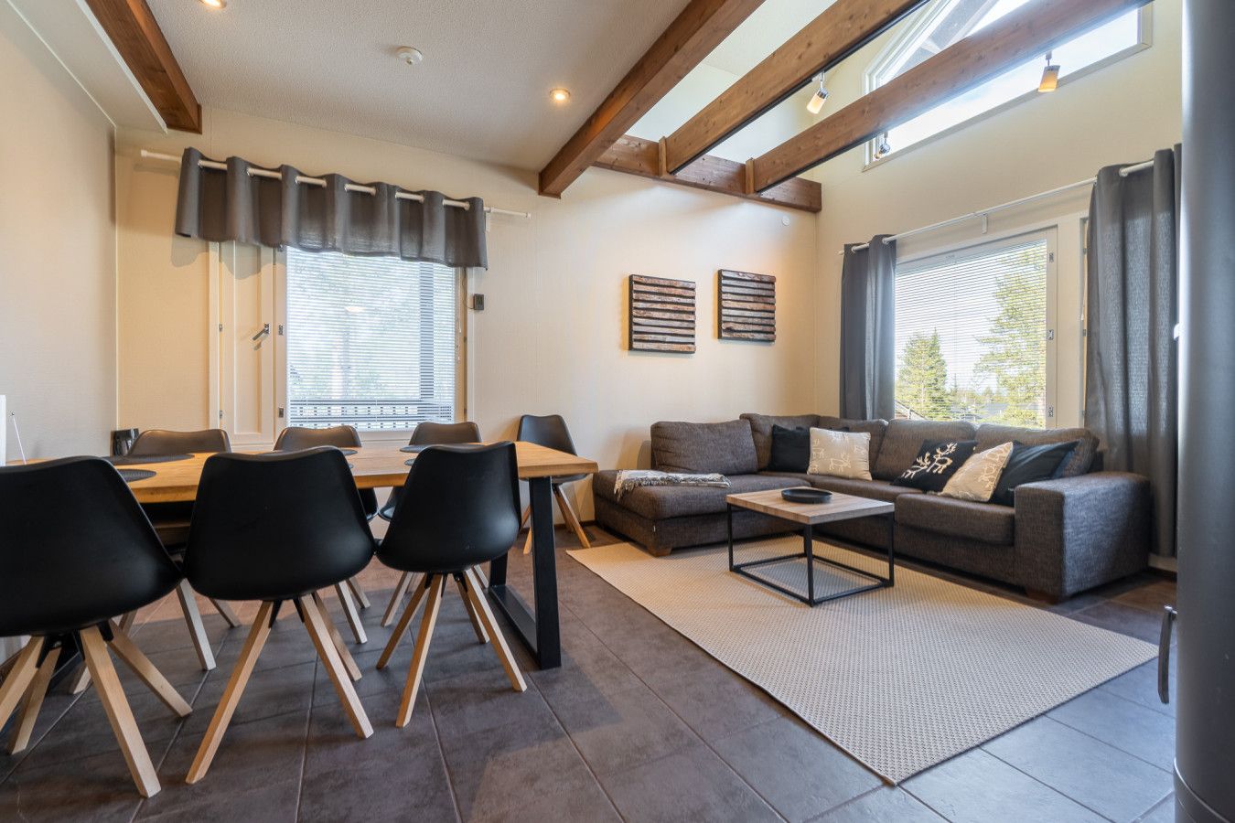 A modern living room with a dining area, featuring a sofa, a coffee table, and a dining table with chairs.