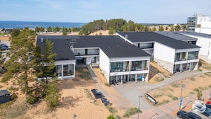 En modern byggnad med flera våningar, en parkeringsplats och utsikt över havet.