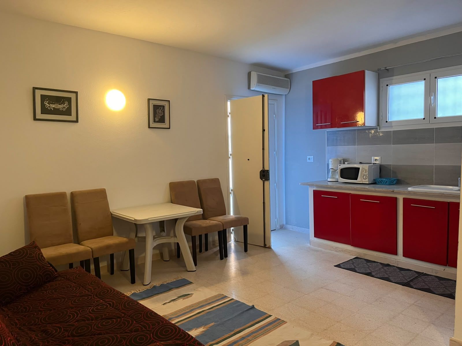 Een knus woongedeelte met eethoek, kitchenette en bed.
