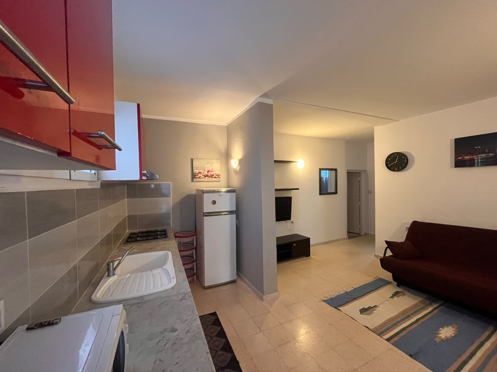 Un espace de vie compact comprenant une kitchenette, un coin repas et un salon.