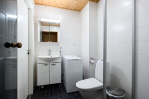 Ein modernes Badezimmer mit einem weißen Waschbecken, einem Spiegel und einer Toilette.