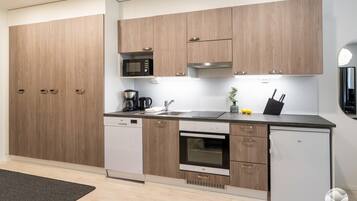 A modern kitchen with wooden cabinets, a built-in microwave, a coffee maker, and a refrigerator.