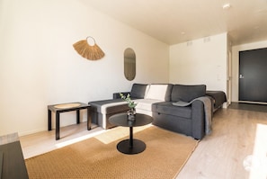 A modern living room with a round coffee table, a sofa, and a small side table.