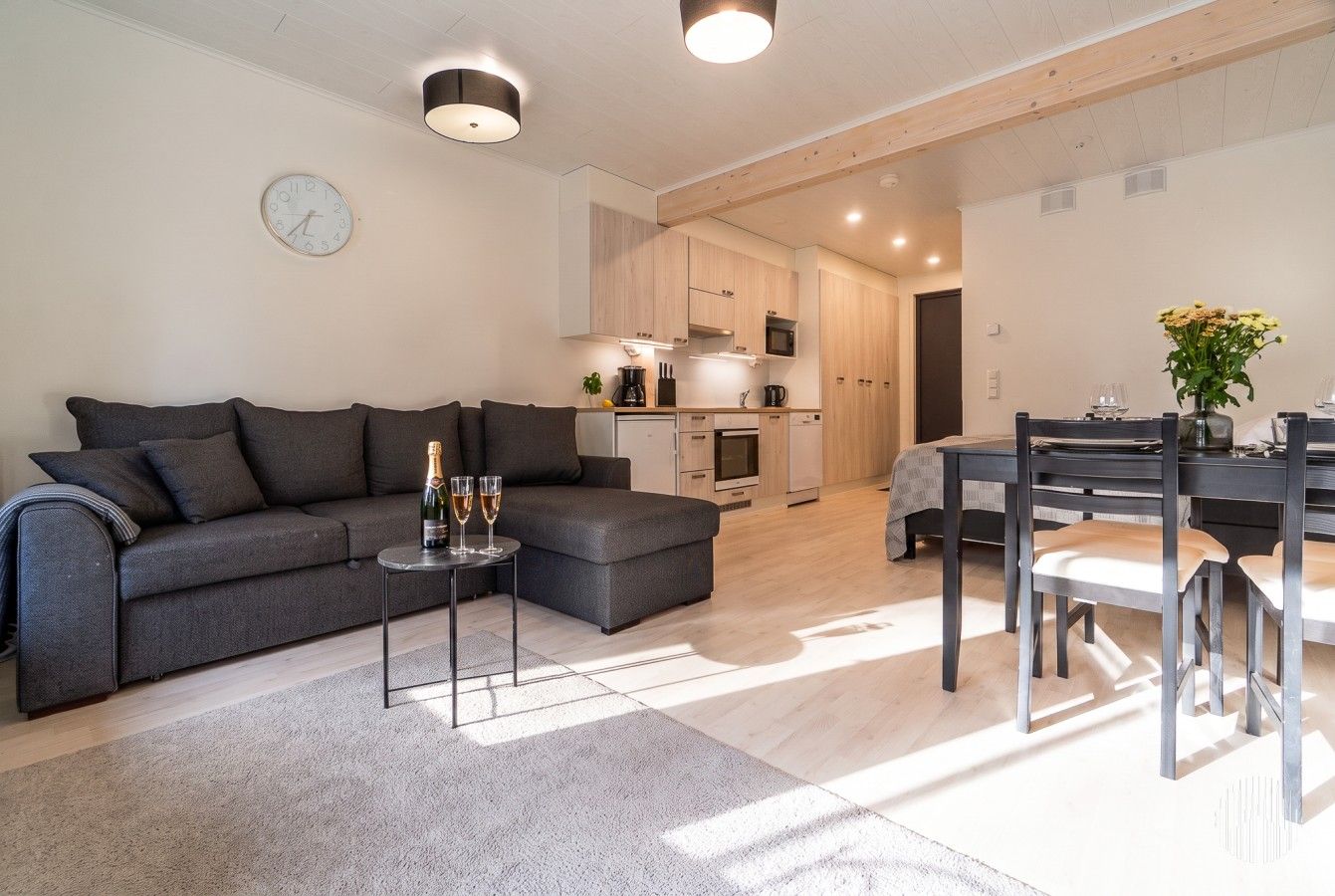 Moderni olohuone, jossa on sohva, sohvapöytä ja ruokailutila tuoleineen.