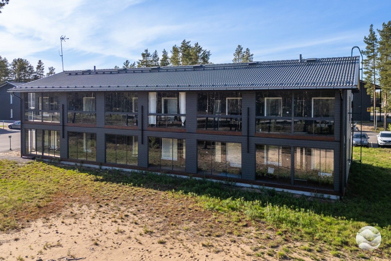 Moderni rakennus, jossa on tasakatto, suuret ikkunat ja selkeästi erotettavissa oleva ulkoalue.